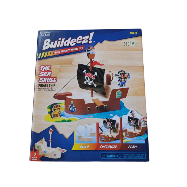 Faber-Castell, Buildeez The Sea Skull Pirate Ship, The Buildeez!™ Pirate Ship is not just another wooden model set, this take on a classic activity means more creativity and more fun in every box.​ Build, paint, sticker and play with this easy wooden model set. Designed to be assembled in a few simple steps, the Buildeez! Pirate Ship is the perfect STEAM and building introduction for young minds. Includes everything you need for your child's first building set - high-quality wooden pieces, paint, stickers, 