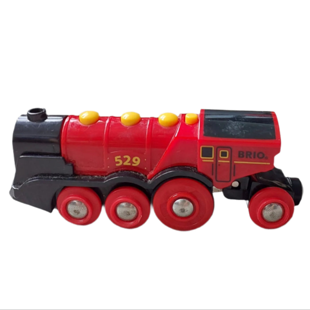 BRIO, Mighty Red Action Locomotive, Keep aspiring train drivers occupied! The large battery operated locomotive has two front lights and manual buttons for "full steam ahead", reverse and the characteristic "choo-choo" sounds. With its two front lights fully lit, full speed ahead and the unmistakable “choo-choo” sound, the 33592 Mighty Red Action Locomotive impresses even the most experienced young train driver.