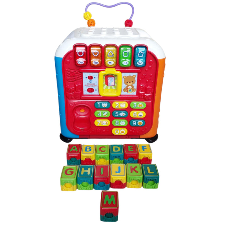 Vtech, Alphabet Activity Cube, The Alphabet Activity Cube by VTech is an interactive learning cube that has five sides of fun to discover! Little builders will love the 13 building blocks that also teach the alphabet. The blocks can be stacked on the top of the cube or they can be inserted into the slot on the electronic side to learn more about each letter. The electronic side also features five piano keys, a number keypad, and telephone. Other sides of this electronic learning toy feature fun mechanical e