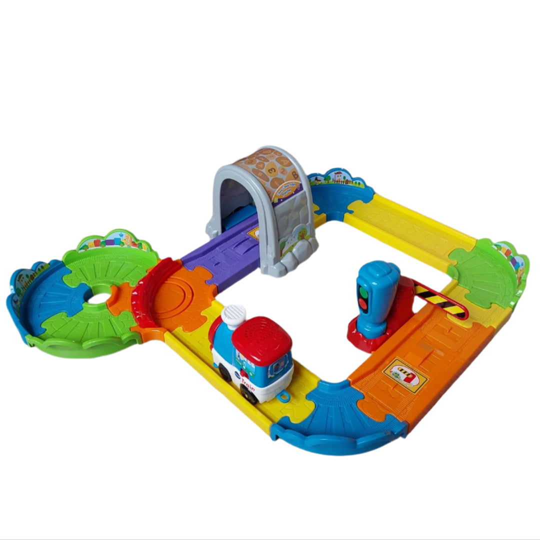 Vtech, Smart Wheels Choo Choo Train Playset, The Go! Go! Smart Wheels Choo-Choo Train Play set from VTech features a motorized train engine that responds with sounds and phrases when crossing over Smart Point locations along the tracks. Your child can arrange the track pieces in a variety of different ways and then watch as the motorized train engine chugs into the tunnel or through the gate.