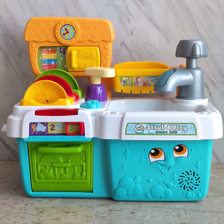 Leapfrog, Scrub and Play Smart Sink Toys Playset, Creative & Imaginative Play, Soak up fun & learning with the Scrub ‘n Play Smart Sink! Count along with the soap pump & hear about colors & size with the talking dish rack. Six accessories included.