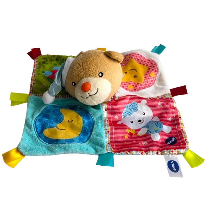 Vtech, Soothing Songs Lovey Blanket Bear, Sensory & Language Development , A snuggle is all that the VTech® Calm Songs LoveyTM is waiting for! For your infant, this cuddly and charming bear is the ideal friend. Little ones can feel protected and at ease with its vibrant design and soft materials and ribbons. Squeezing the bear's ear will allow your infant to hear charming sentences and calming music. The detachable electronics make it simple to care for the blanket.