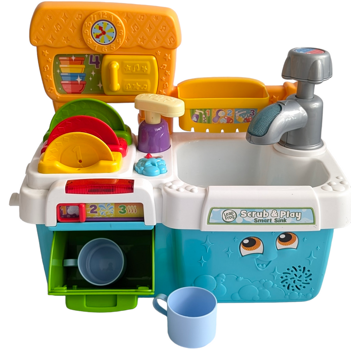 Leapfrog, Scrub and Play Smart Sink Toys Playset, Creative & Imaginative Play, Soak up fun & learning with the Scrub ‘n Play Smart Sink! Count along with the soap pump & hear about colors & size with the talking dish rack. Six accessories included.